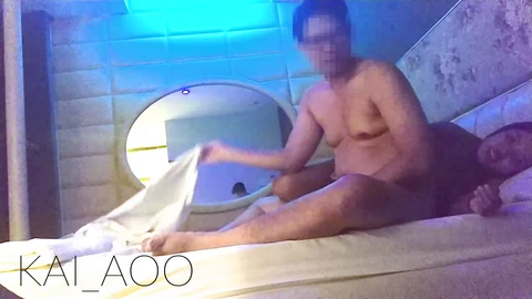 Asiatische Masseurin mit großen Brüsten und einem saftigen Hintern gibt eine sinnliche Massage